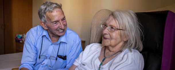 Older man and woman smiling in care home 