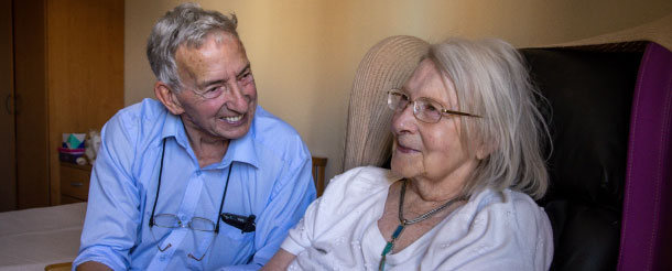 Older man and woman smiling in care home