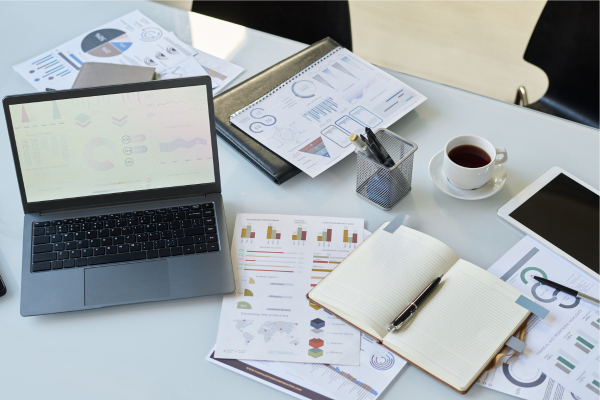 A work desk with papers and a laptop