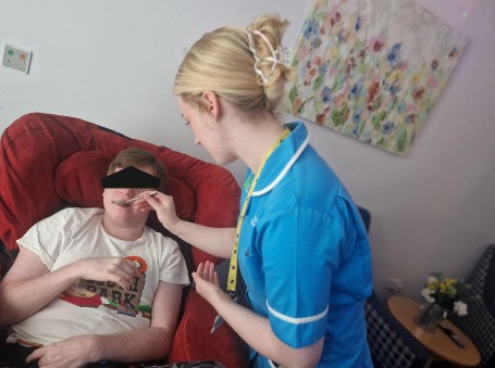 Staff using feeding apparatus for resident