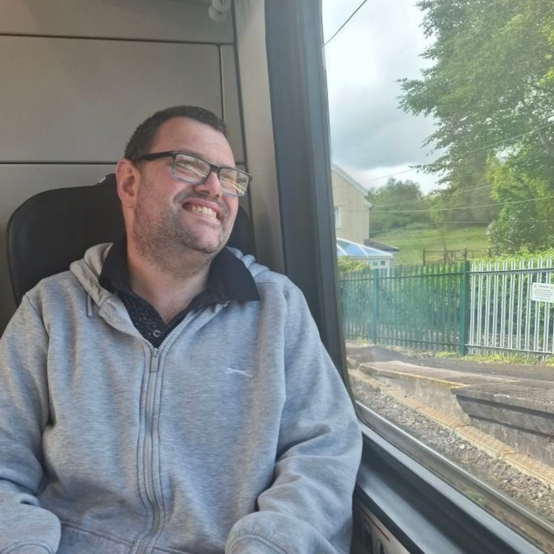 Expanding Horizons resident on a train smiling