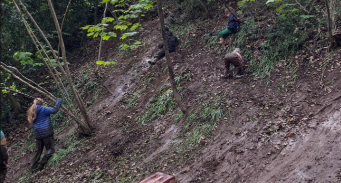 Children climbing on a muddy slope