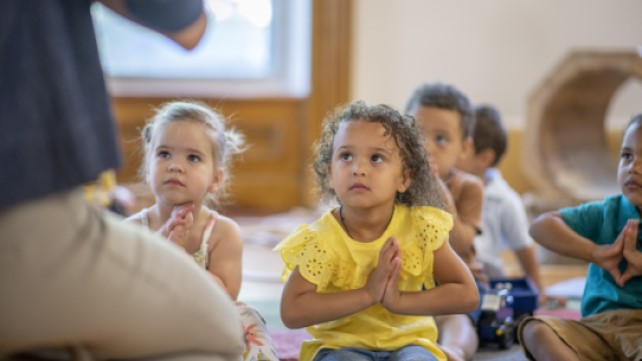 Group of in the classroom doing yoga and listening to the teacher.